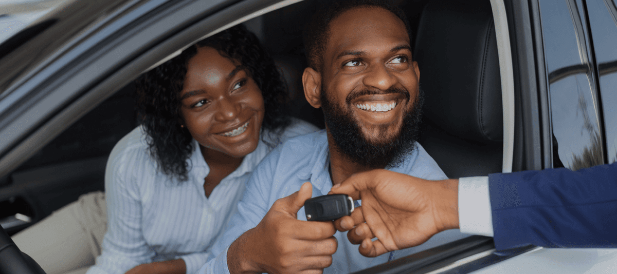 Happy couple receiving car keys